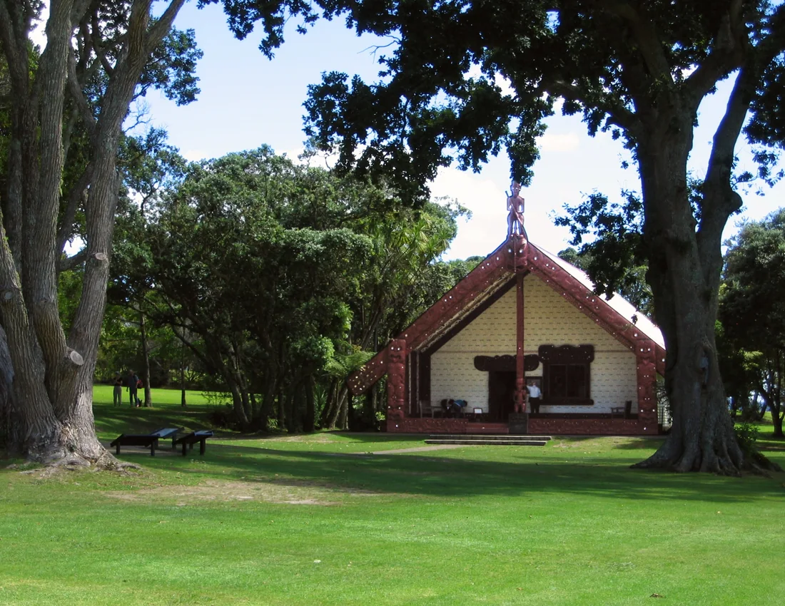 The carved meeting house Te Whare Rūnanga seen across the lawn at the Waitangi Treaty Grounds on a clear day